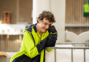 Factory hand Digby Thomas smiling at the camera in front of timber machinery