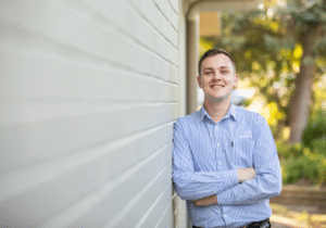 Kurrajong People and Culture officer Nick Dennis leaning against a wall, smiling at the camera