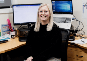 Kurrajong First Contact coordinator of supports Tayla Carey sitting in her office in front of her computer.