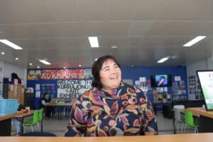 Carlie Fuller stands at the counter of the Kurrajong Griffith office, smiling into the distance.